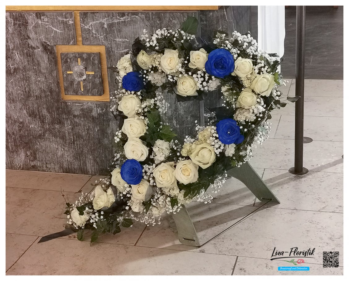 Gesteck in herzform mit blauen und weißen Rosen