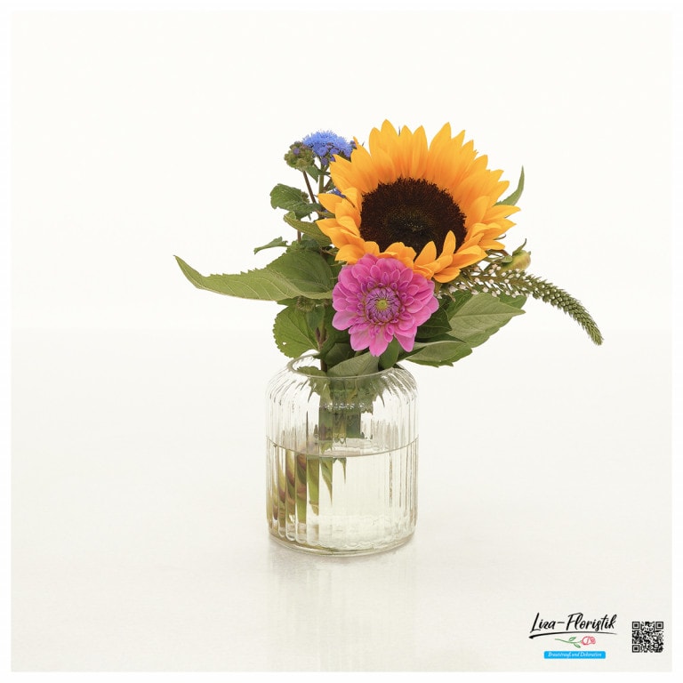 Tischdekoration mit Sonnenblume, Dahlie und Ageratum