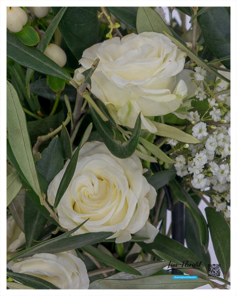 Nahaufnahme cremefarbener Polyantharosen mit weichen Blütenblättern – eingebettet in grünes Blattwerk für einen eleganten, natürlichen Look.