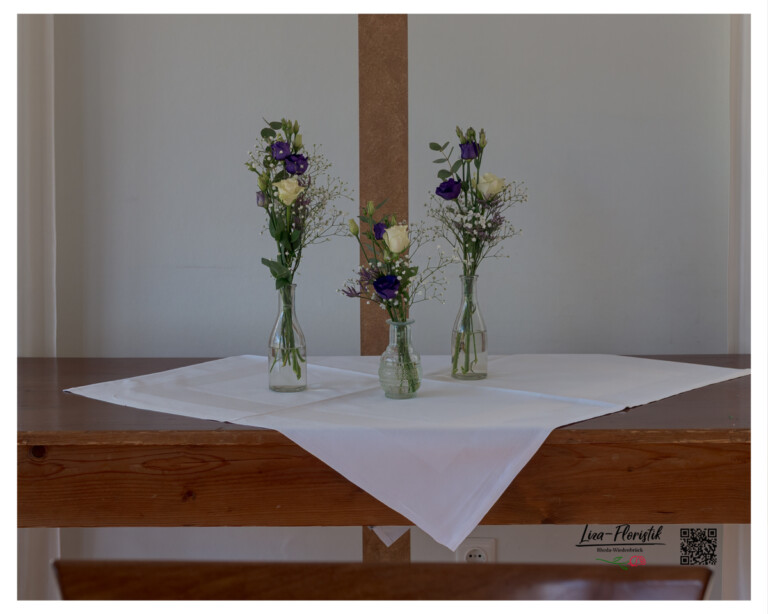 Drei zarte Glasvasen mit Rosen, Lysianthus, Statice und Eukalyptus als stimmungsvolle Tischdekoration für eine Feier bei Gütersloh